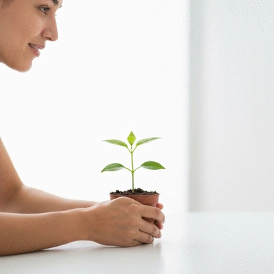 Person patiently waiting for a plant to grow, symbolizing long-term SEO