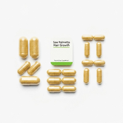 Arrangement of natural hair growth supplements like Saw Palmetto, Biotin, and Zinc capsules on a clean background