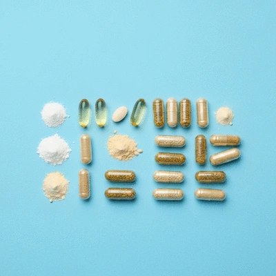 Concept image of various vitamins and minerals in capsules and powders, neatly arranged on a clean background, representing hair growth supplements